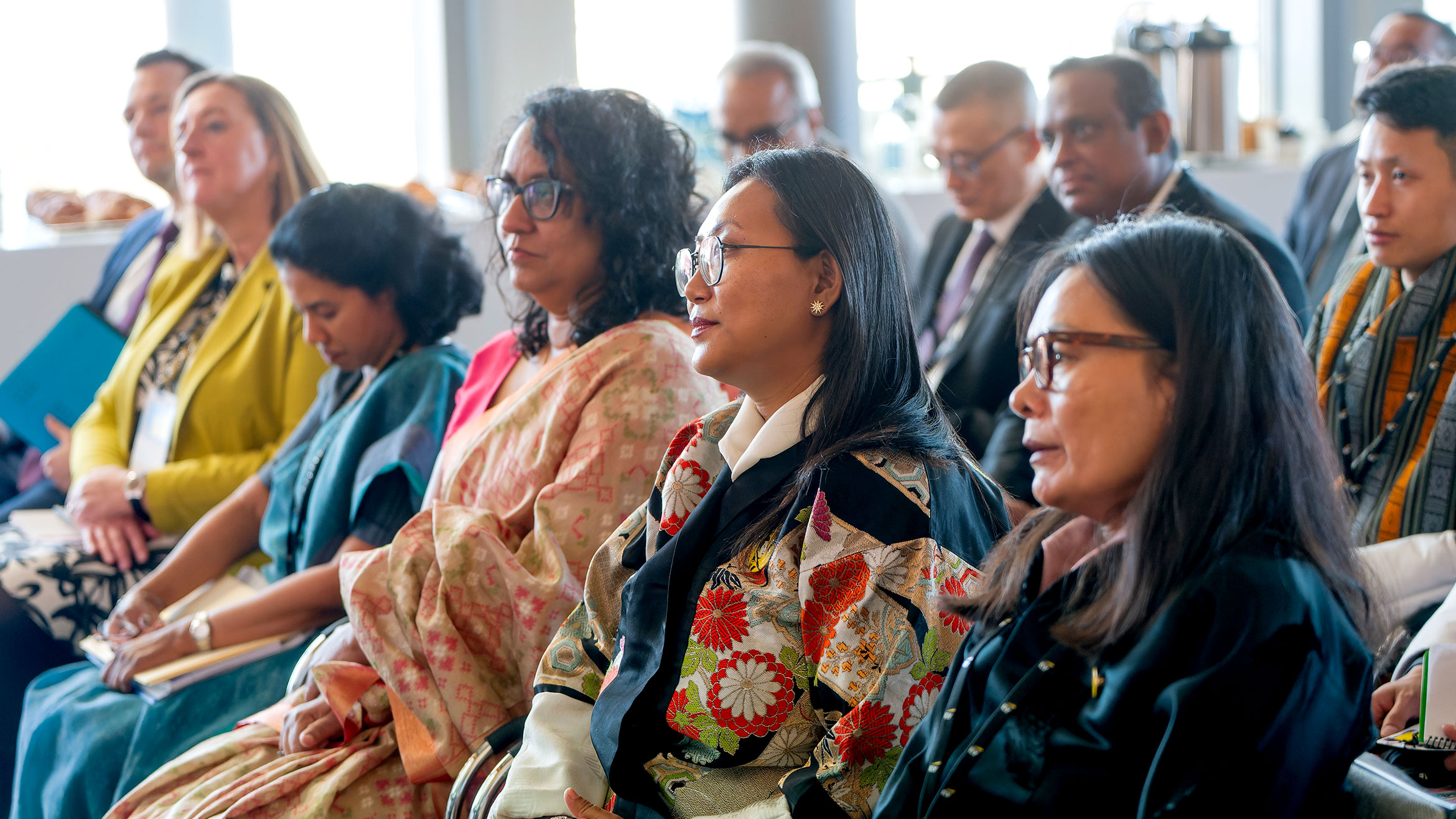 participants sit in a row and listen to a speaker
