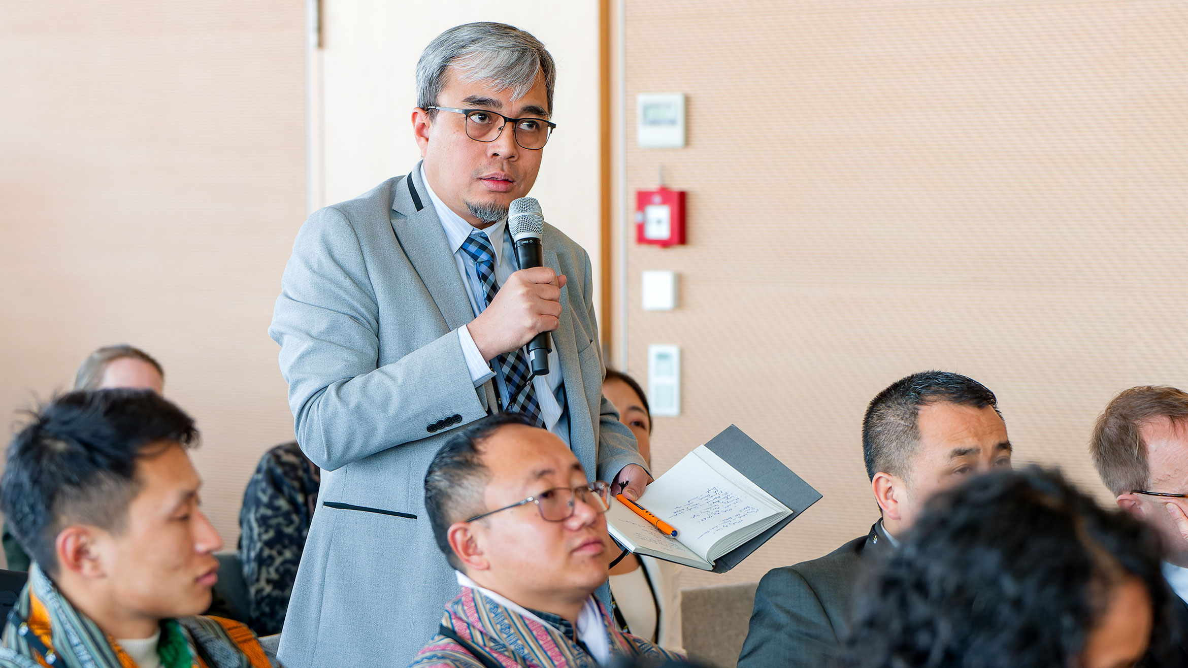participant standing and speaking in a microphone in his hand