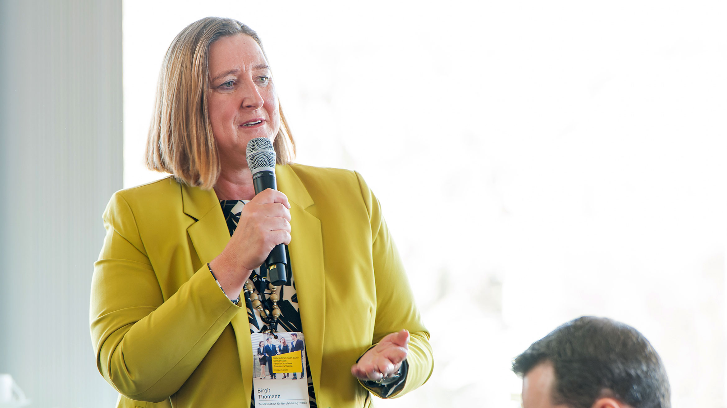 woman from the audience standing and speaking into a microphone