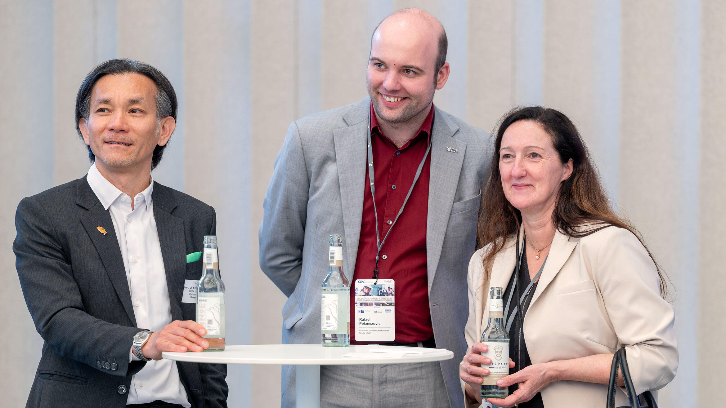 two men and a woman looking in the same direction and smiling