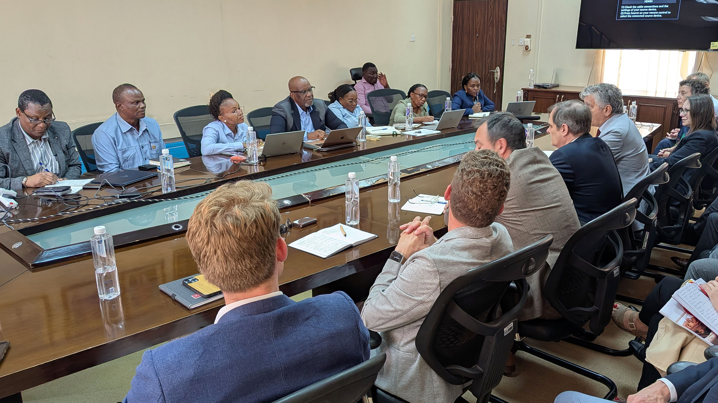 Delegation and host sit at a large U-shaped table