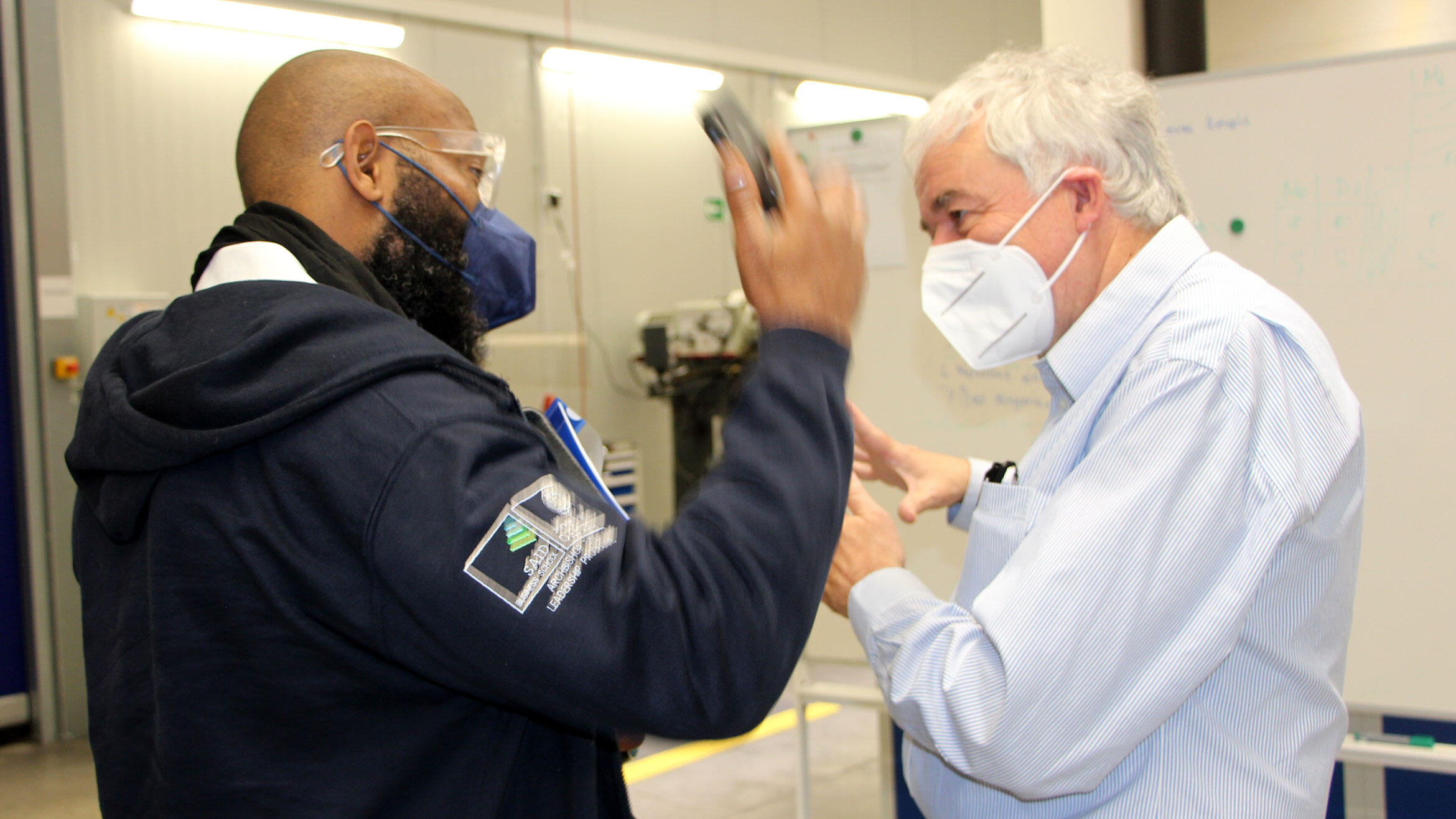 two people in discussion during the tour of a training workshop