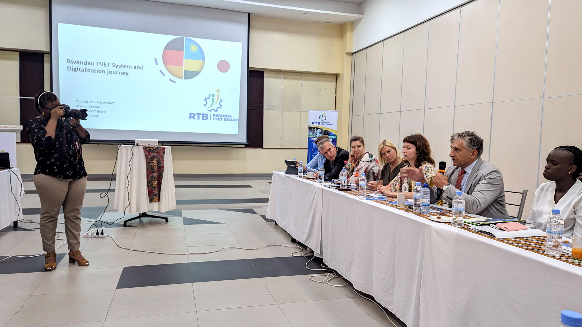 African woman photographs the delegation during the presentation of their digital education solutions