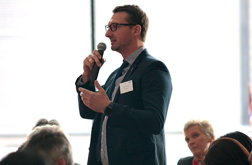 participant asking a question to speakers on the podium