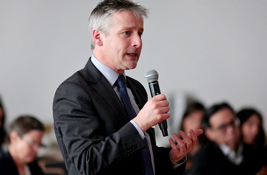 participant asking a question to speakers on the podium
