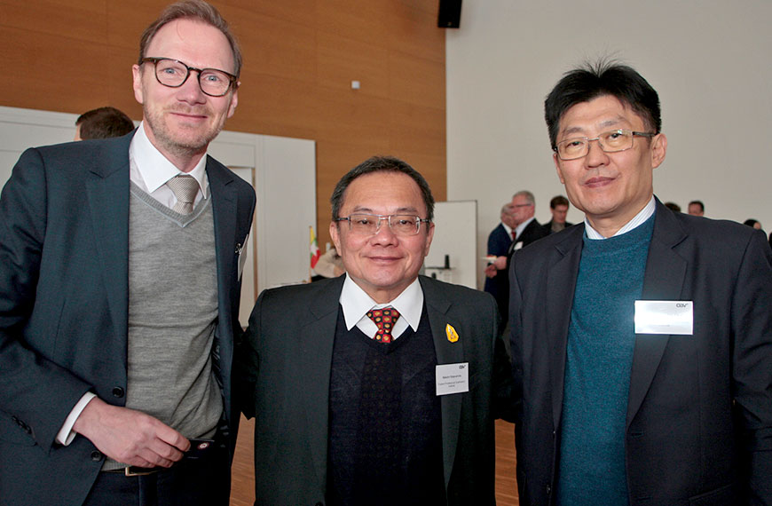 three people smiling into the camera