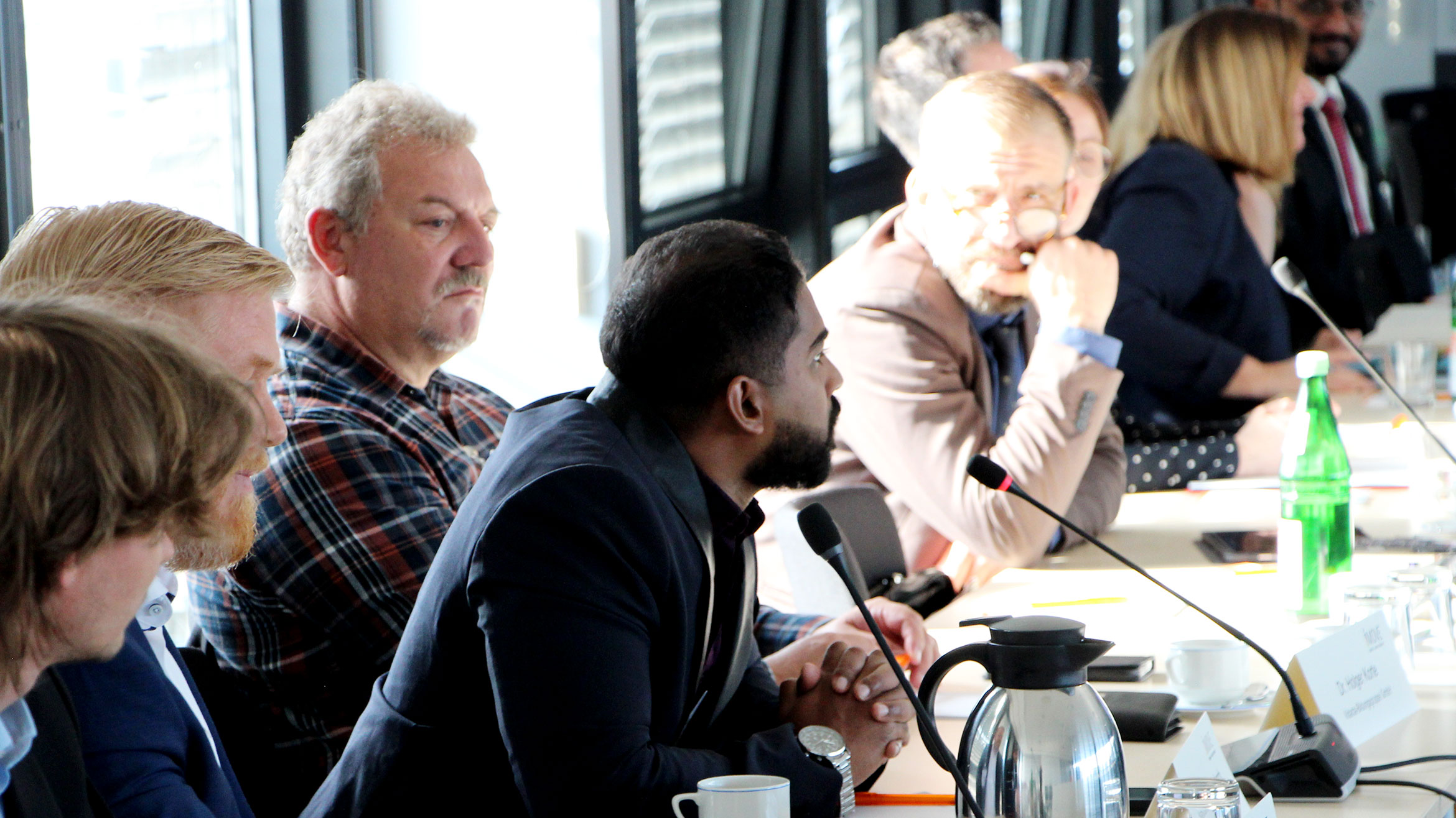 Row of seats with some participants at the first round table