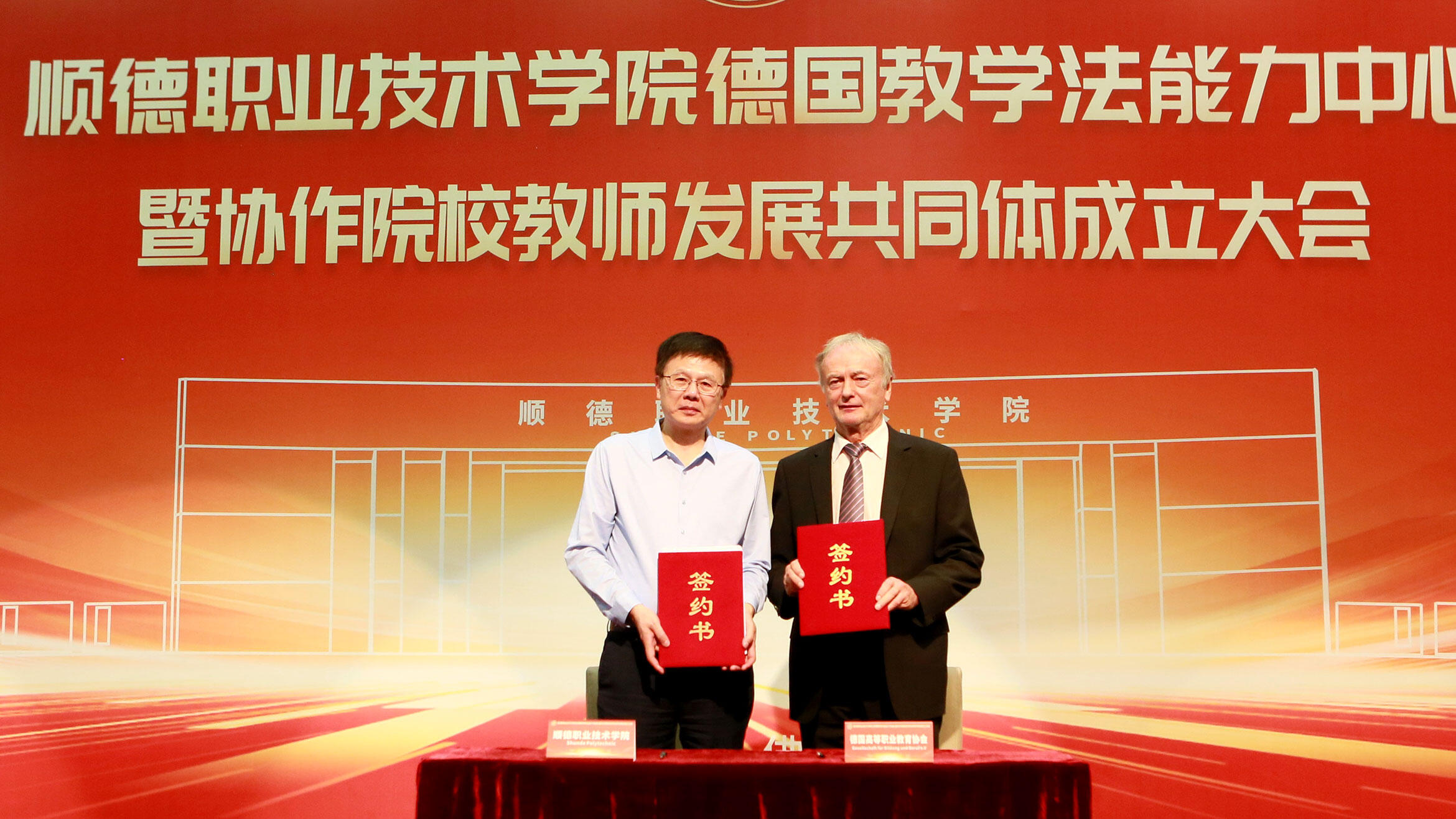 A Chinese man and a German man hold up certificates to the camera