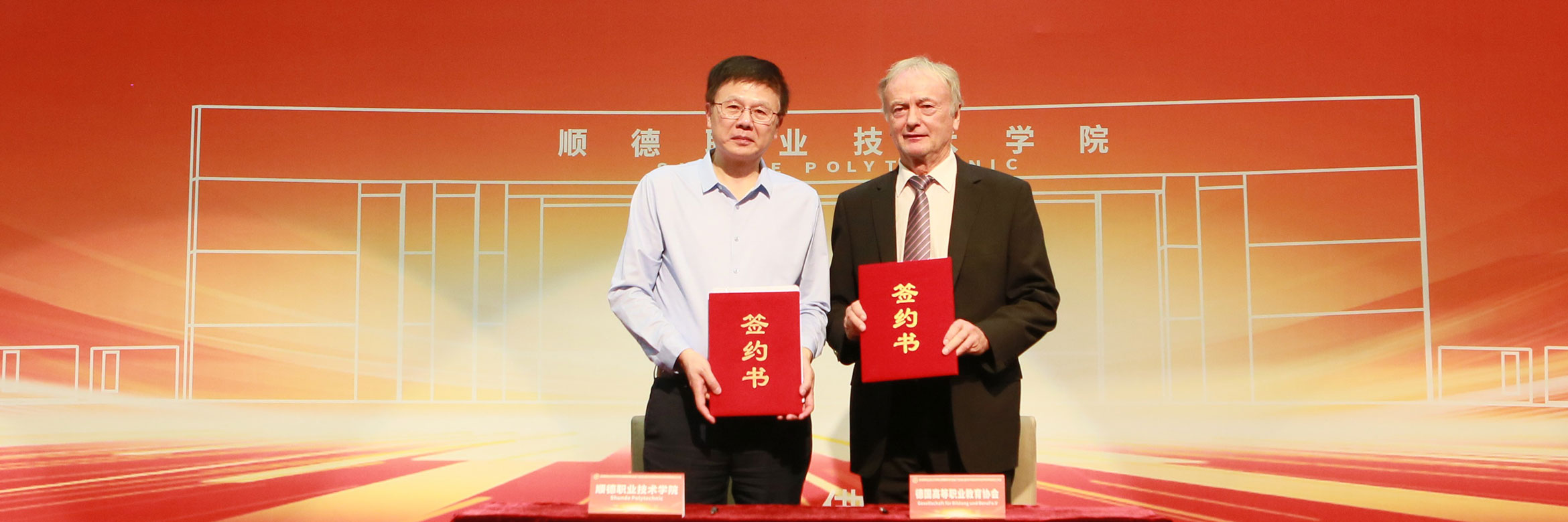 A Chinese man and a German man hold up certificates to the camera