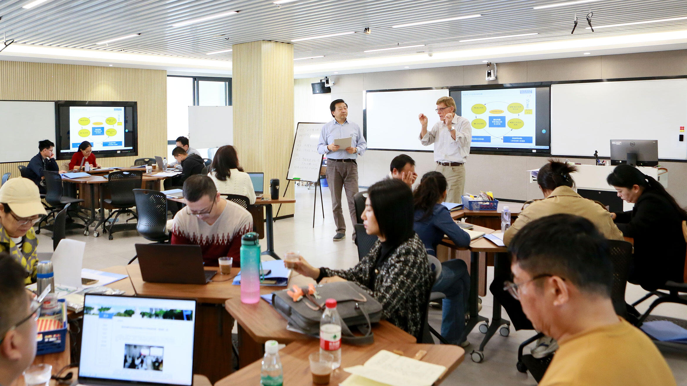 A glance into a teaching room showing Chinese people sitting in groups