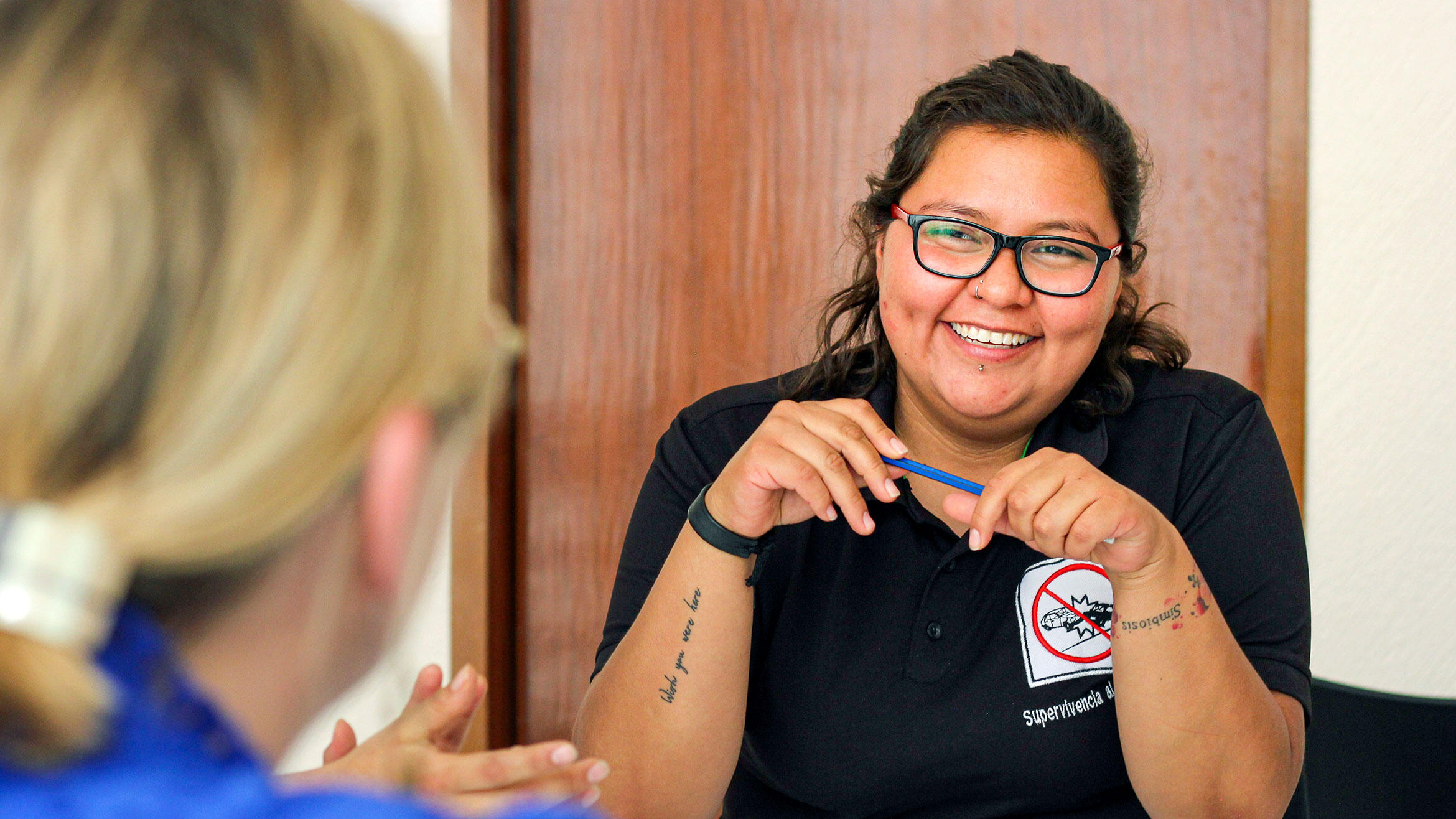 Mexican woman sitting at a table was photographed over the head of a second woman