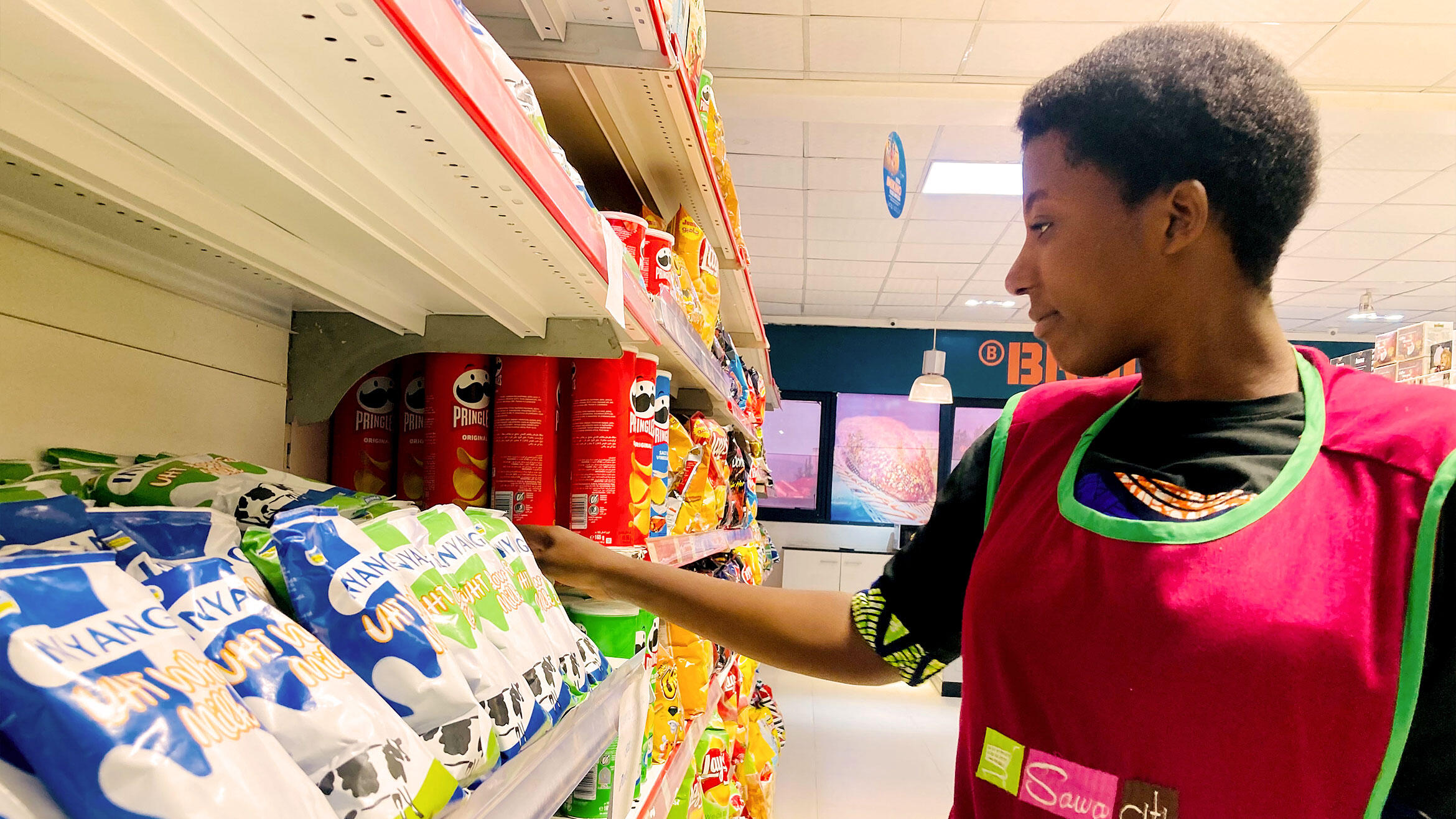 African woman checks a supermarket shelf