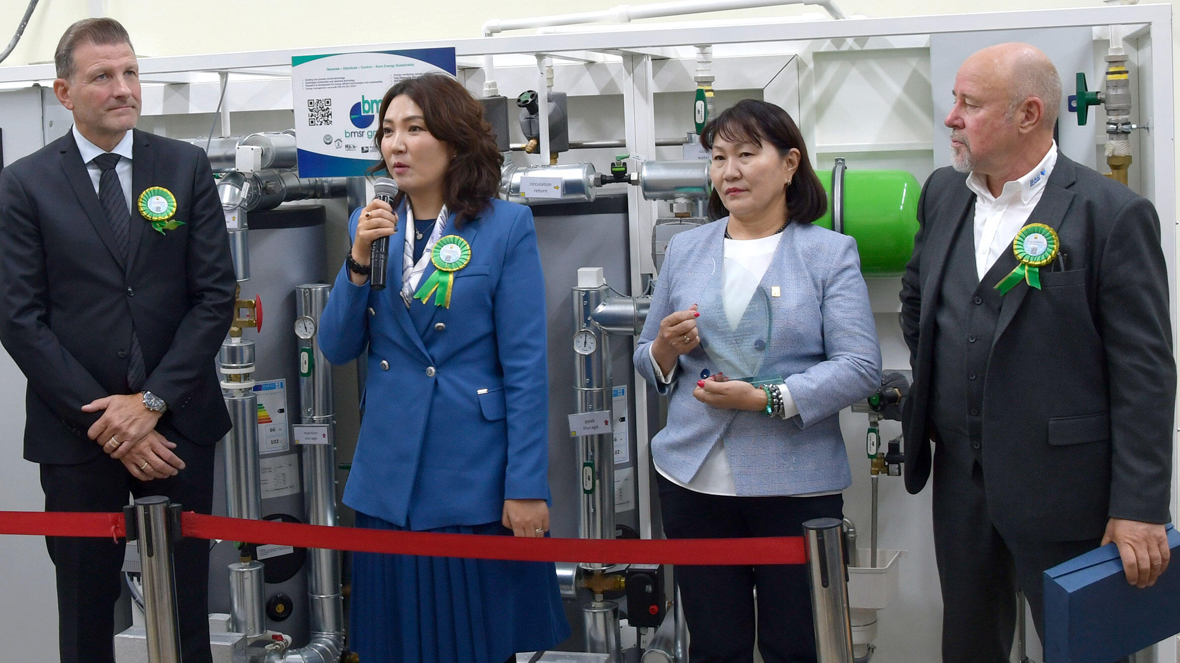 Four people in front of a drinking water treatment facility