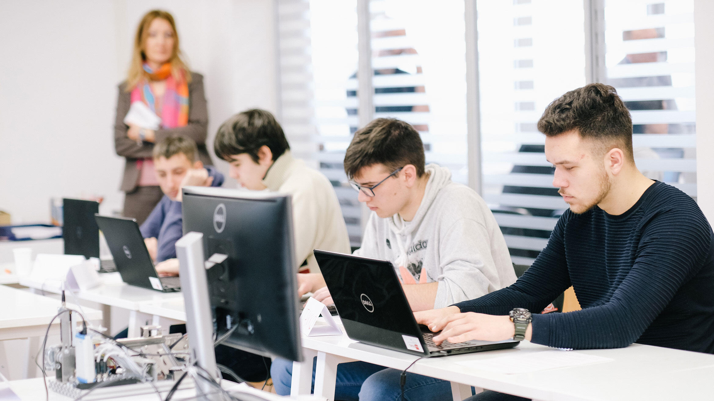 Serbs working at the computer, trainer in the background