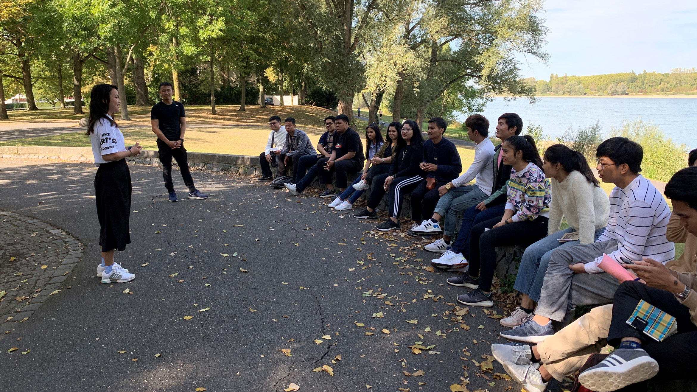 several Thai people sit together in an open-air meeting 