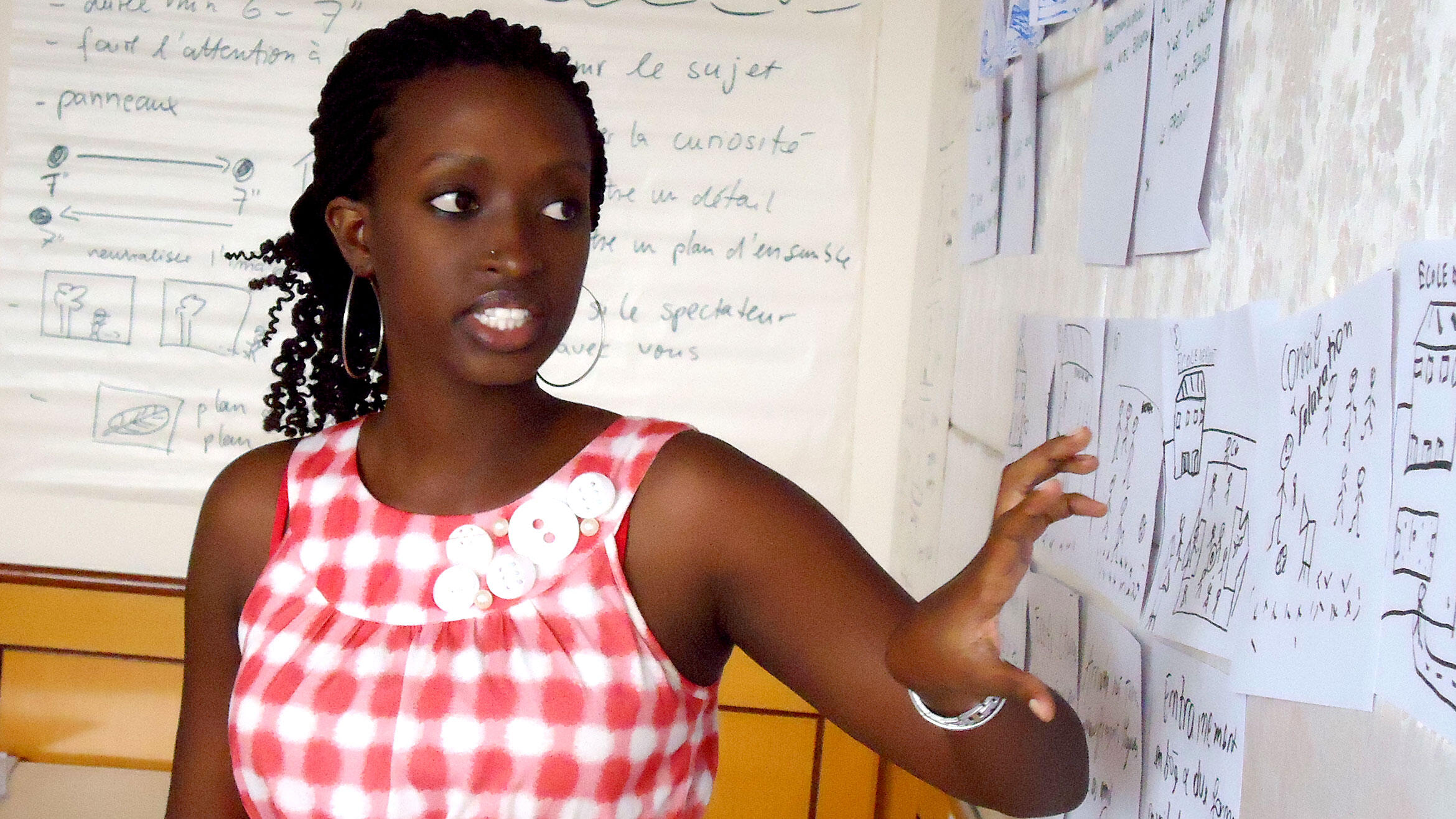 African woman explains something at a board