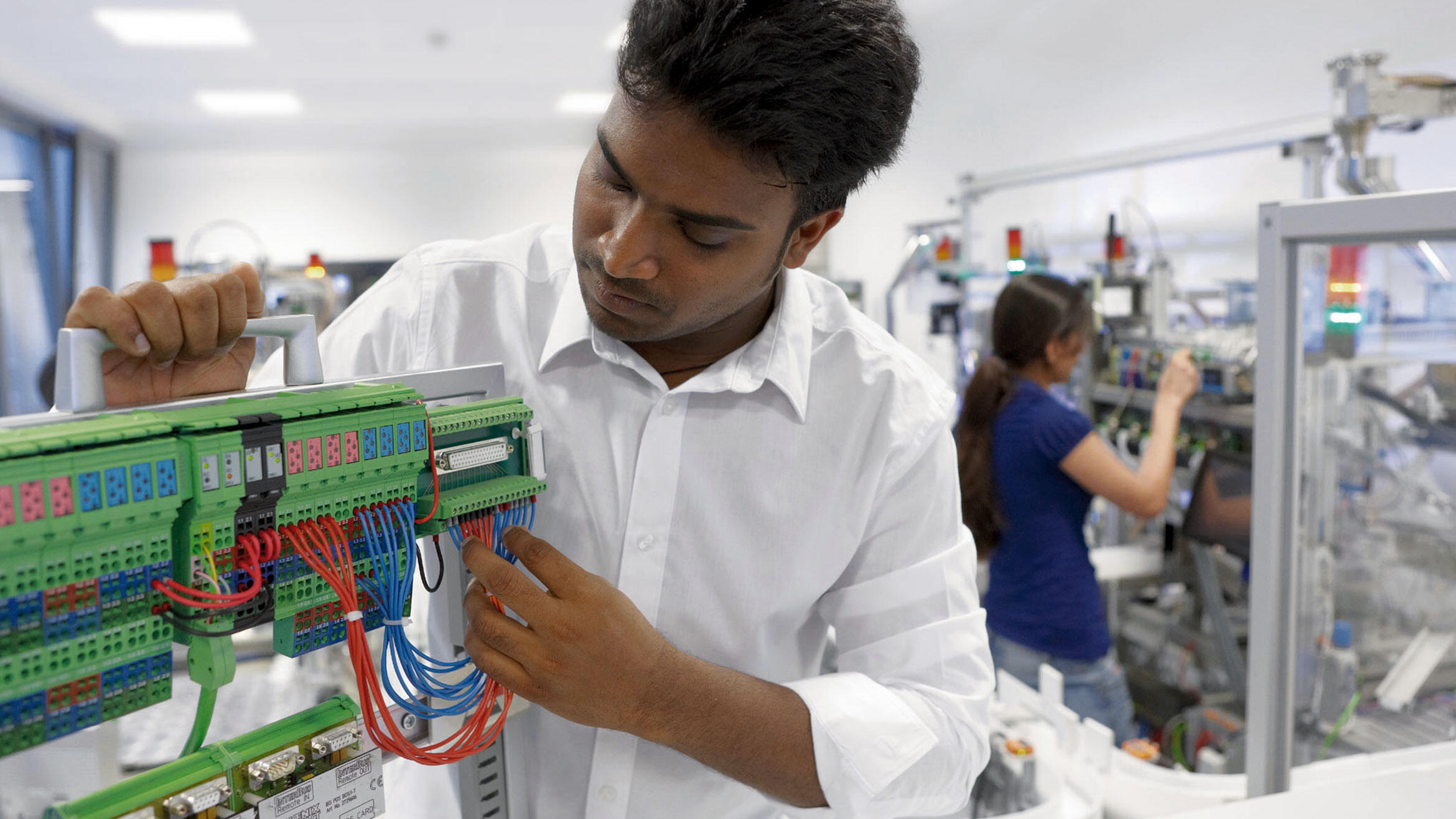 man from Southeast Asia in a workshop working in the area of eletronic