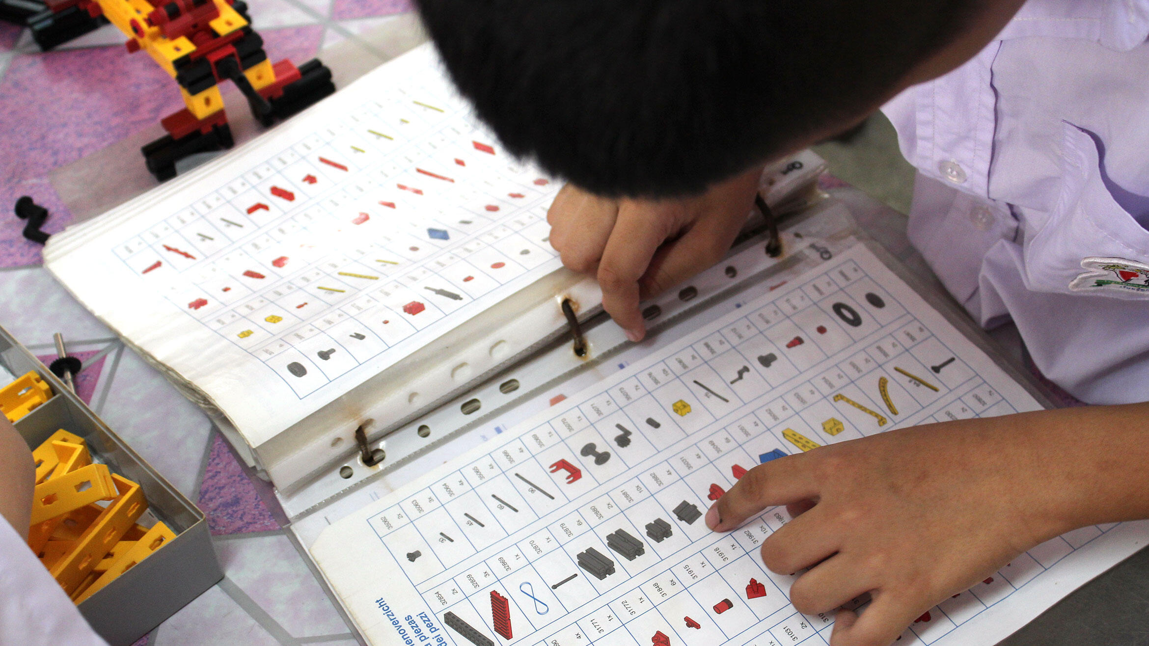 Asian kids play with technical game pieces