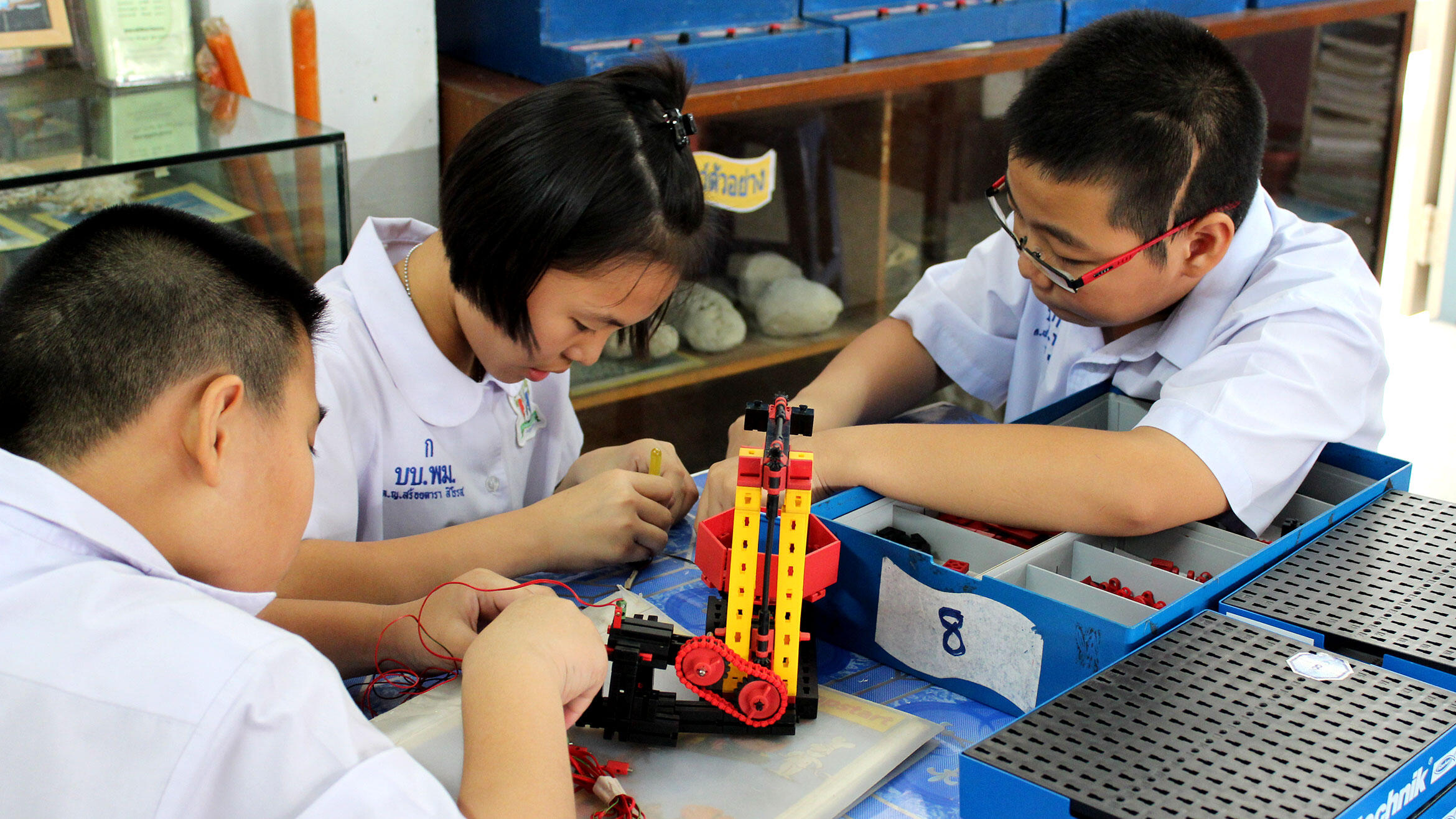 Asian kids play with technical game pieces