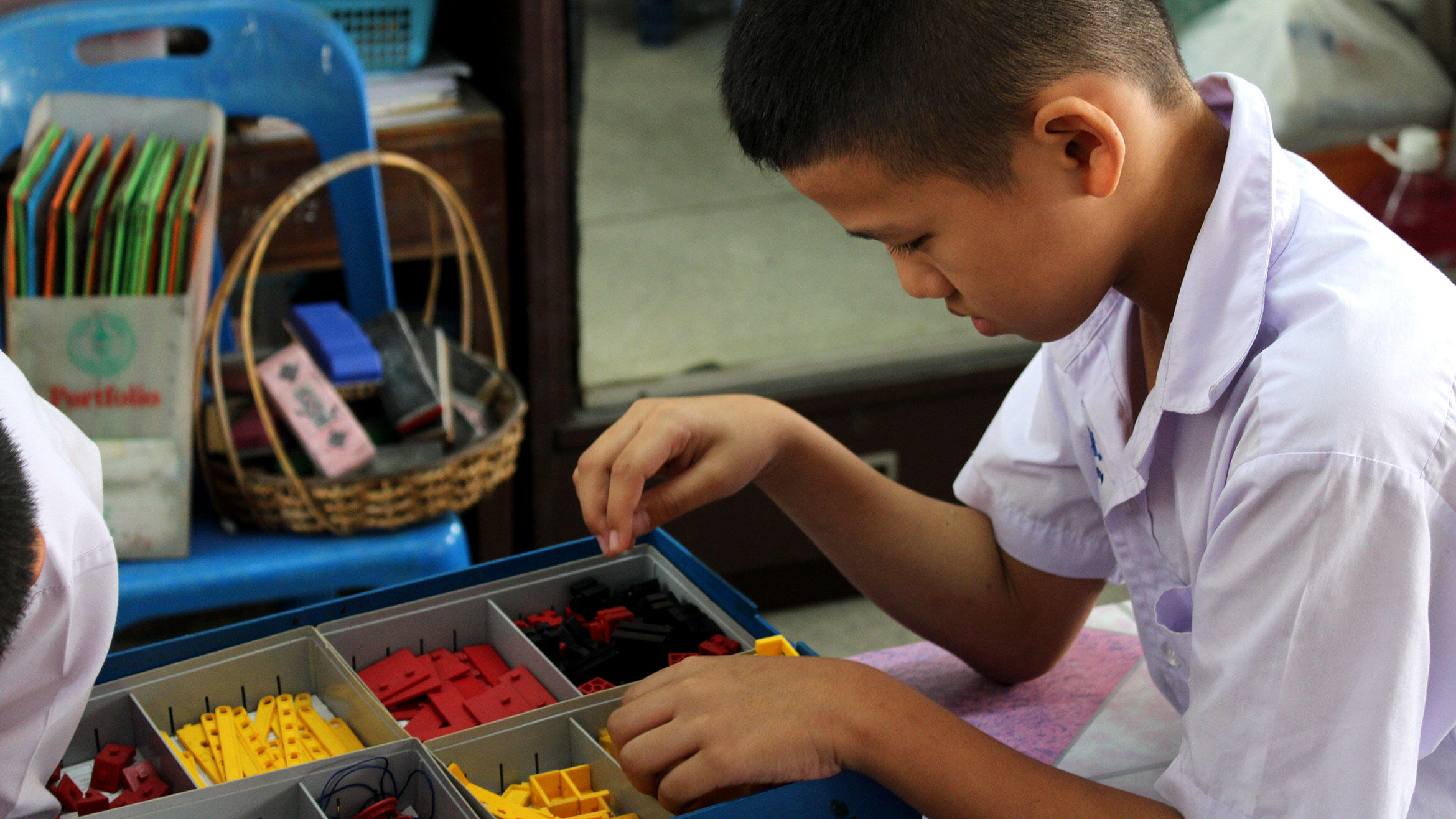 Asian boy plays with technical game pieces