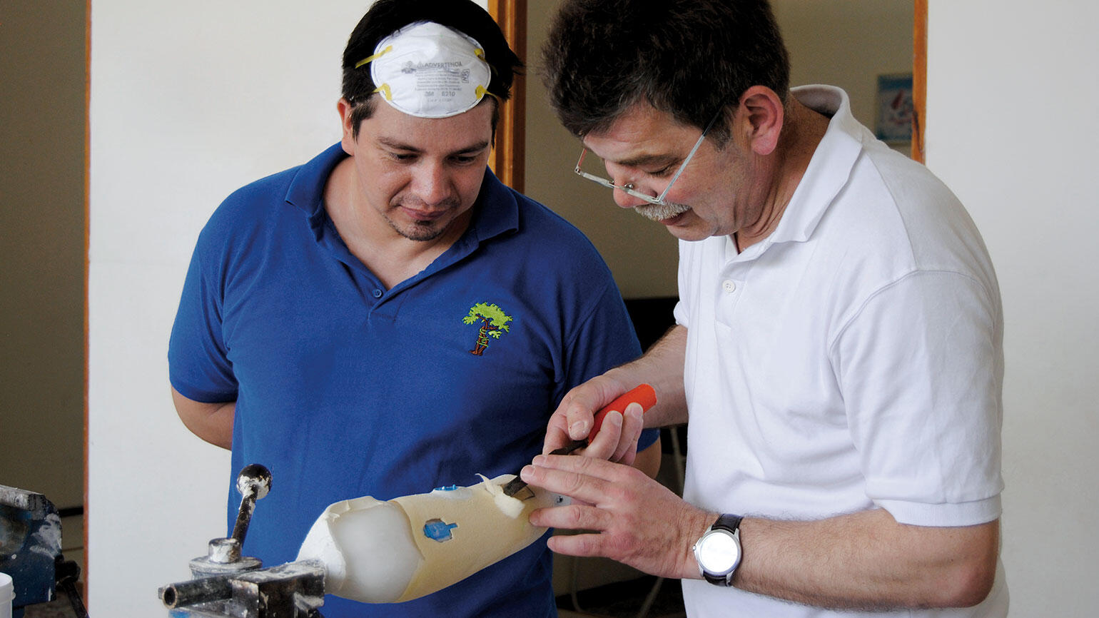 Trainee observes trainer working on an artificial limb 