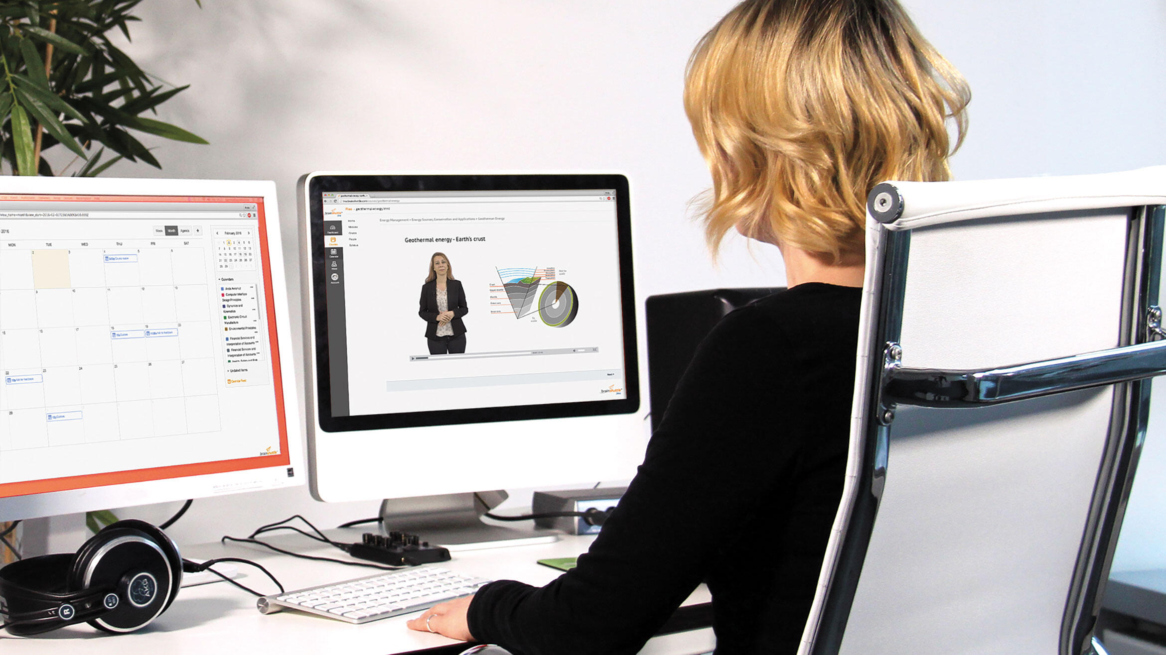 Women sitting at a table looking at two monitors