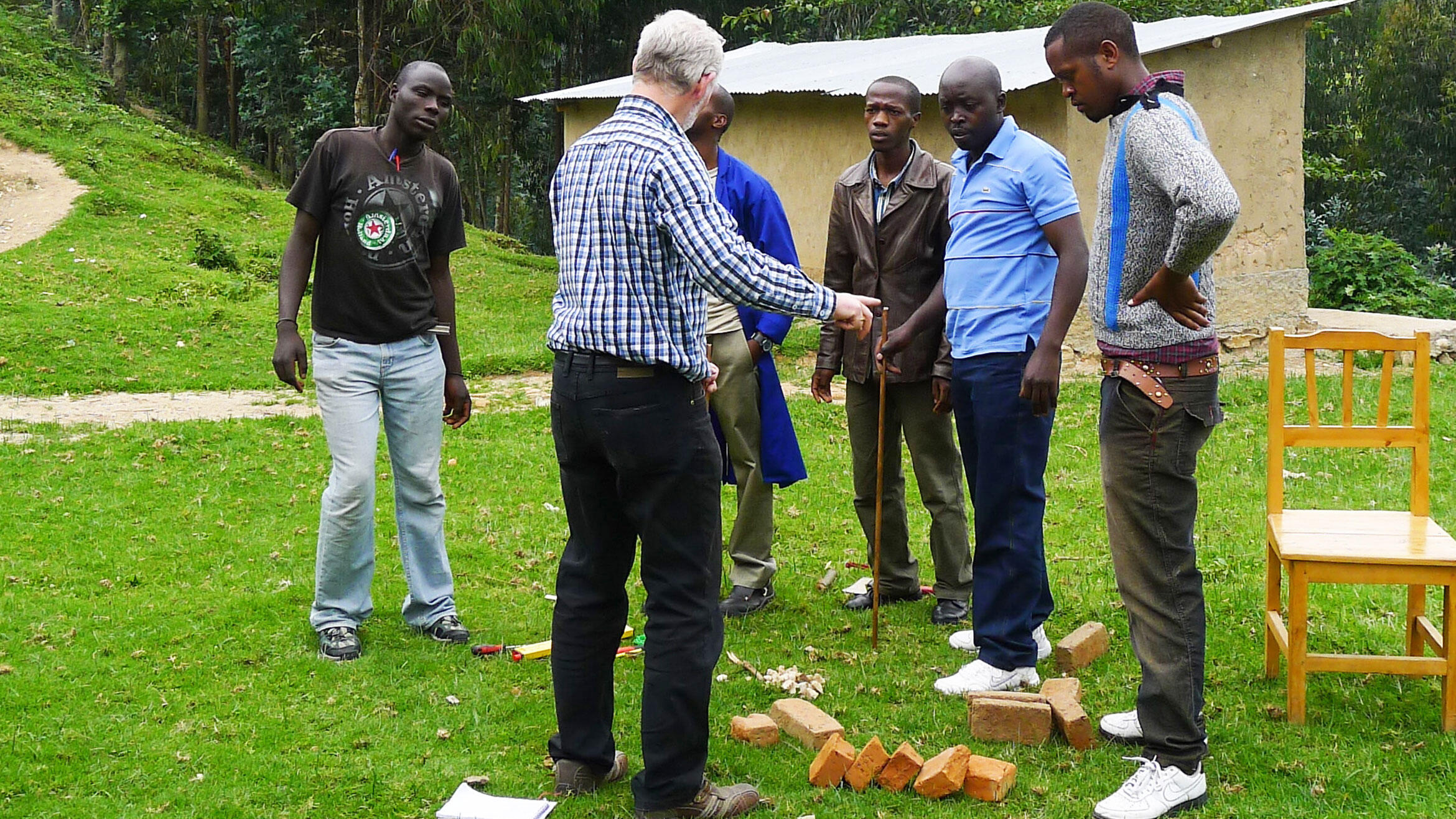 teacher from Germany shows young men from Rwanda something from the field of construction