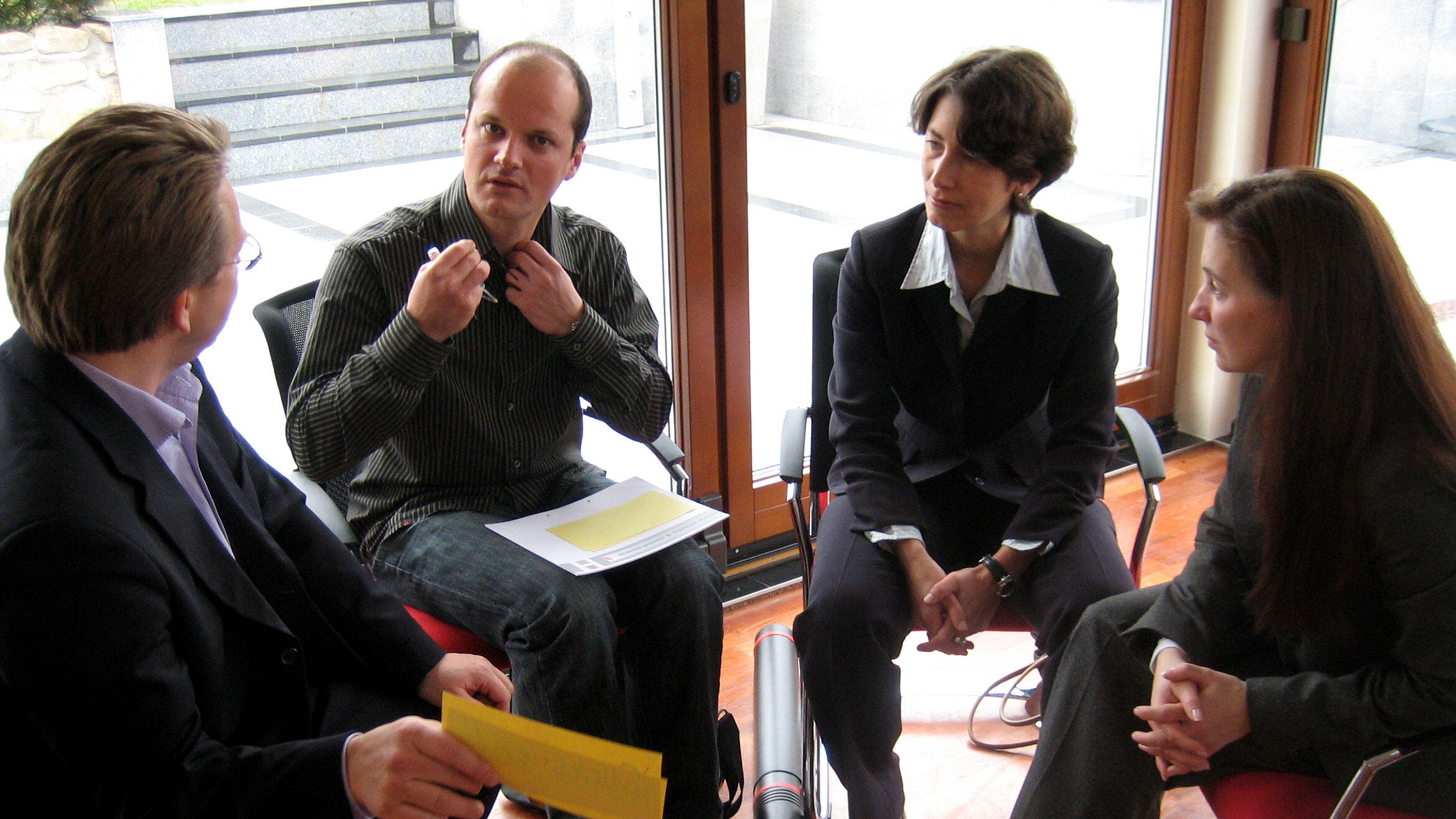 four people sitting in a circle and discuss