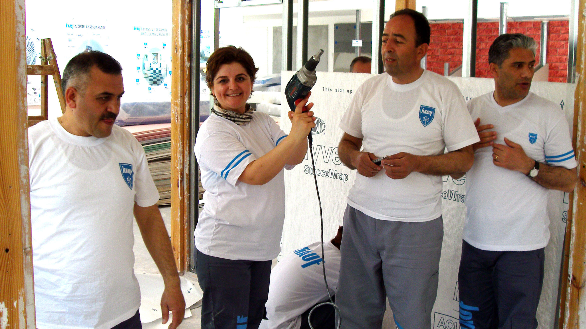 group picture with four people, a woman holds a drill machine