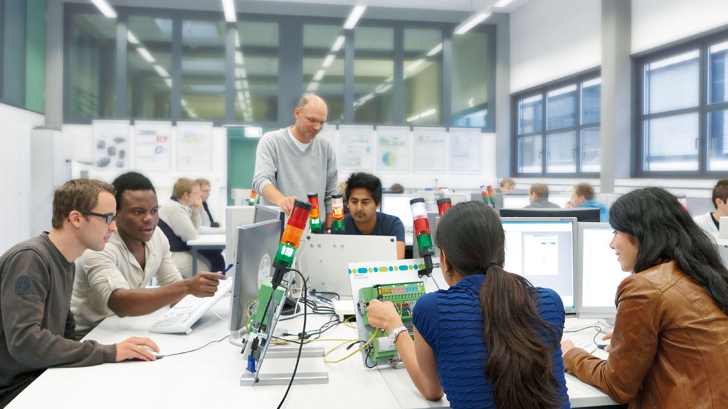 people in a workshop working on electronical equipment