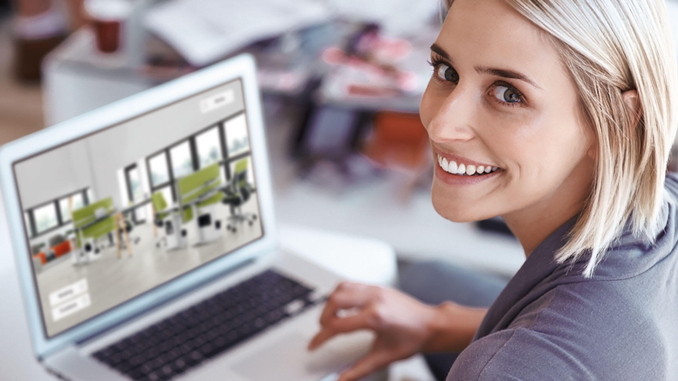 woman in front of a computer smiling into the camera