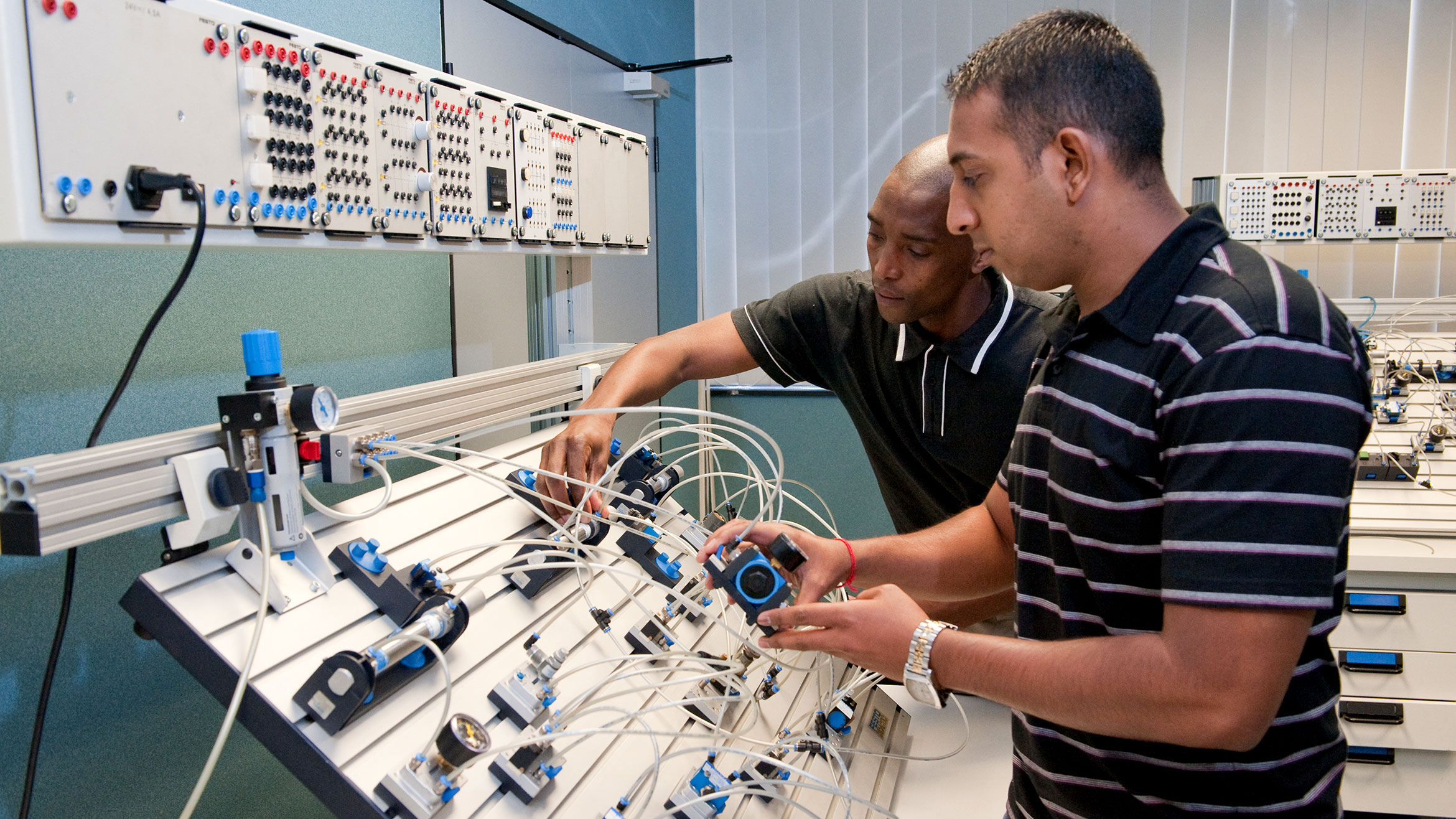 two men connect cables to a training facility