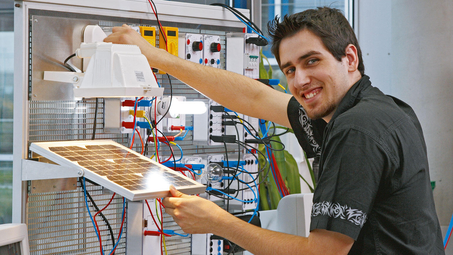 trainee in a workshop smiles into the camera