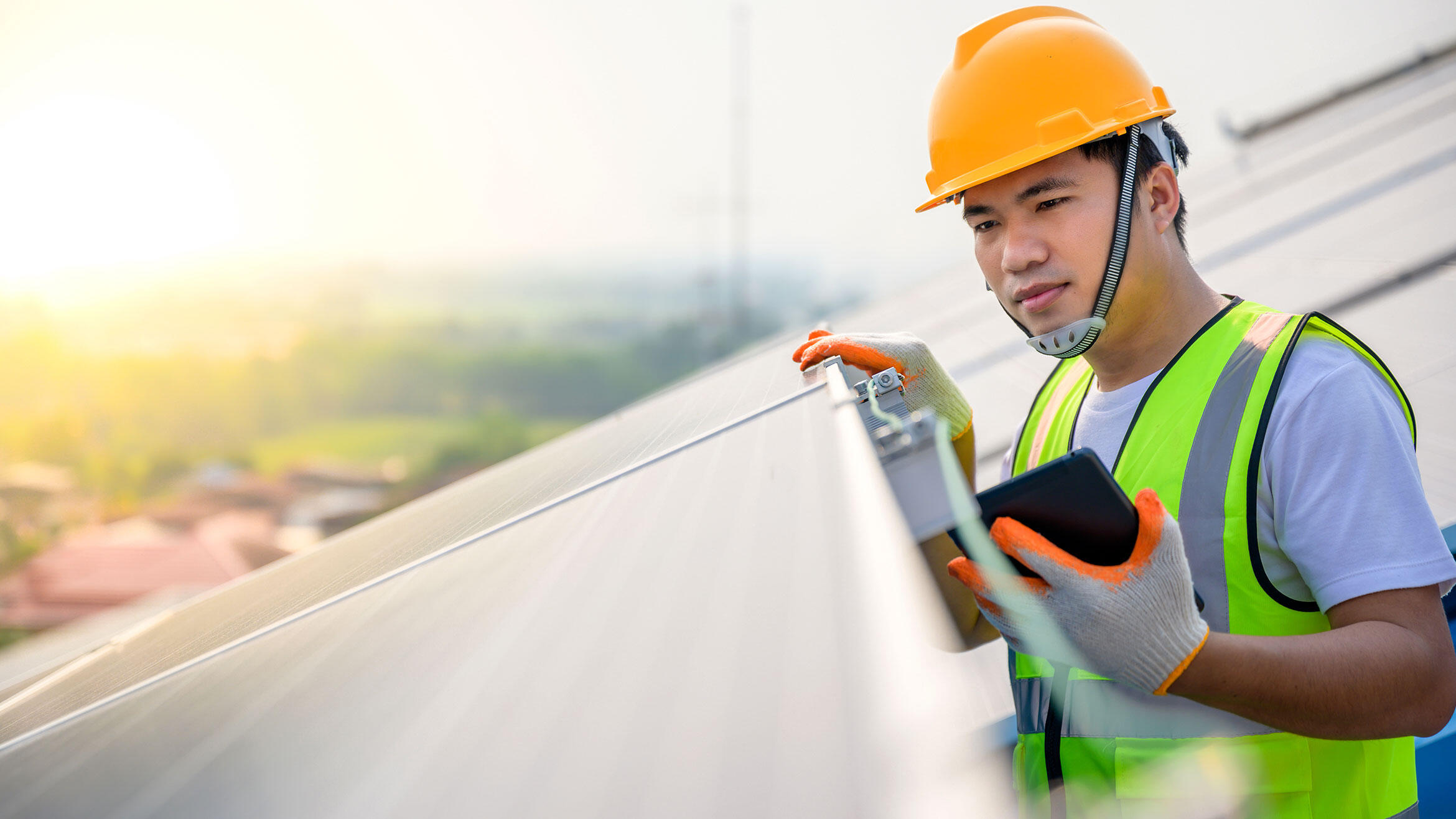 young man from Asia controls photovoltaic system