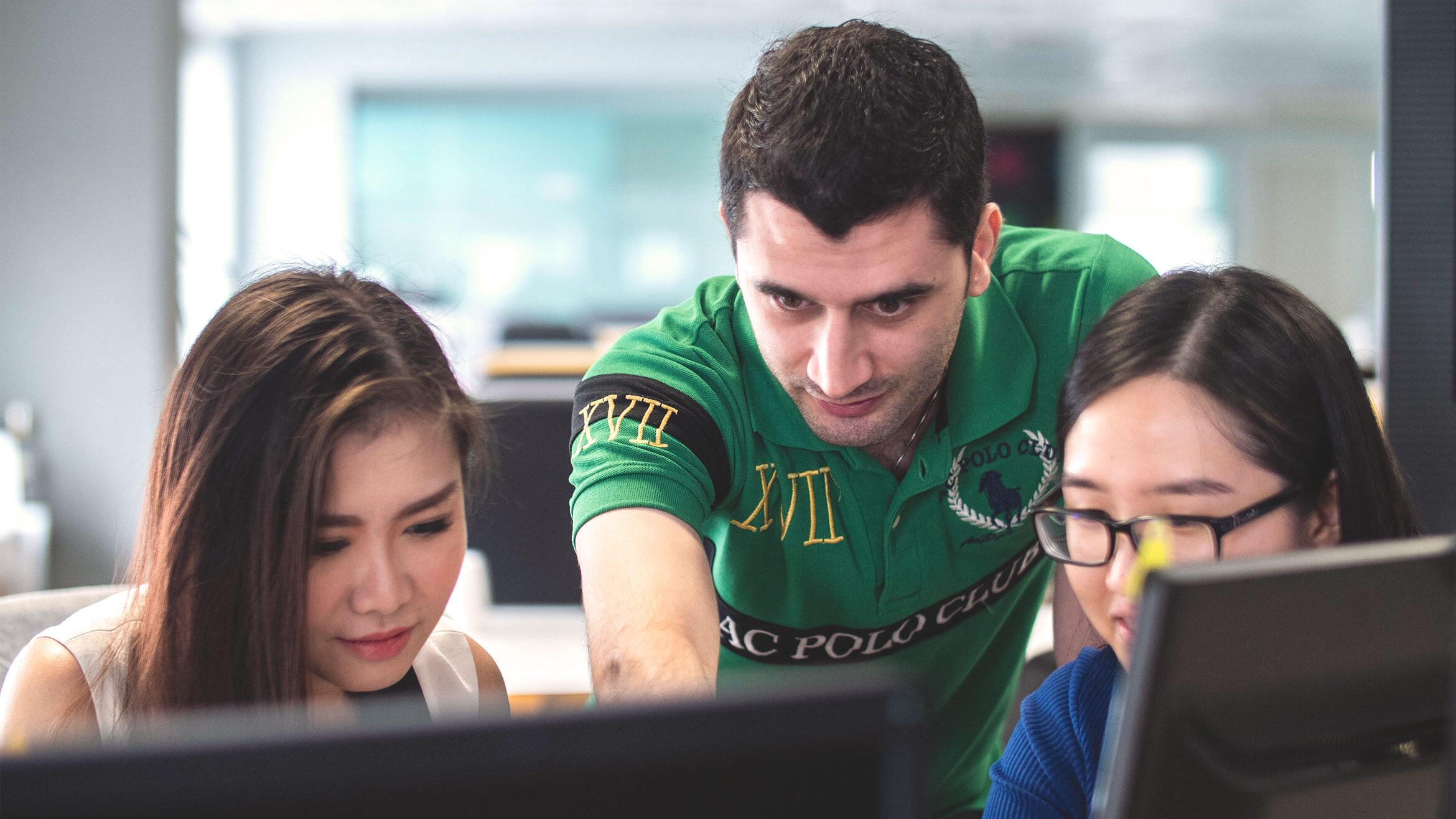 three people look at a screen