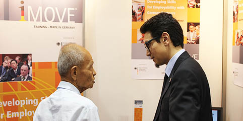 two men talking at the iMOVE information stand