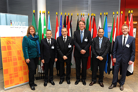 group photo in front of flags of Arab countries with speakers at the opening ceremony