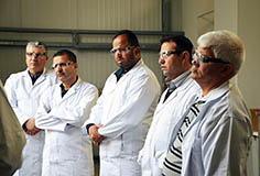 several men standing in white work coats