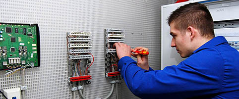 trainee working on electronic panel on the wall 