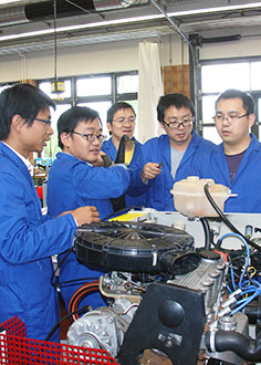 several Chinese trainees working on an automotive machine
