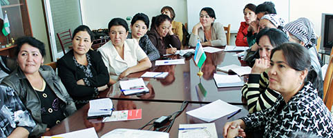 several women sitting at a table in a classroom