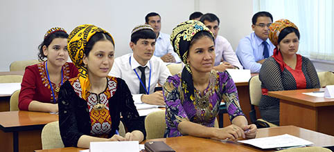 classroom with men and women from Turkmenistan in colourful traditional clothings