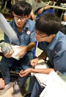 Two Chinese inspect a can