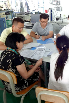 several chinese sitting around a table and discuss something