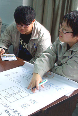 two chinese speaking about a poster