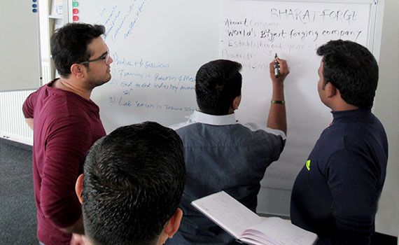 Several men writing on a chart