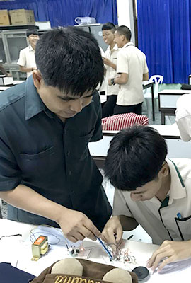 two Thai men work in the field of electrics