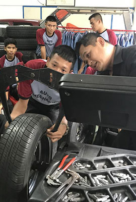 two Thai men study a motor