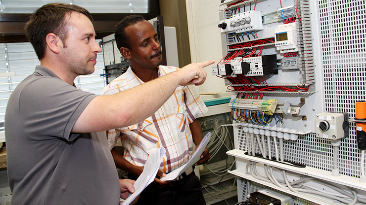 Trainer explains something on a switchboard