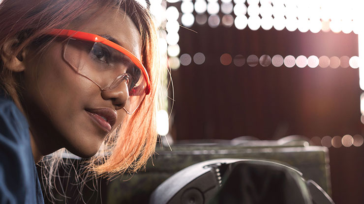 Woman with protective goggles looks past the camera